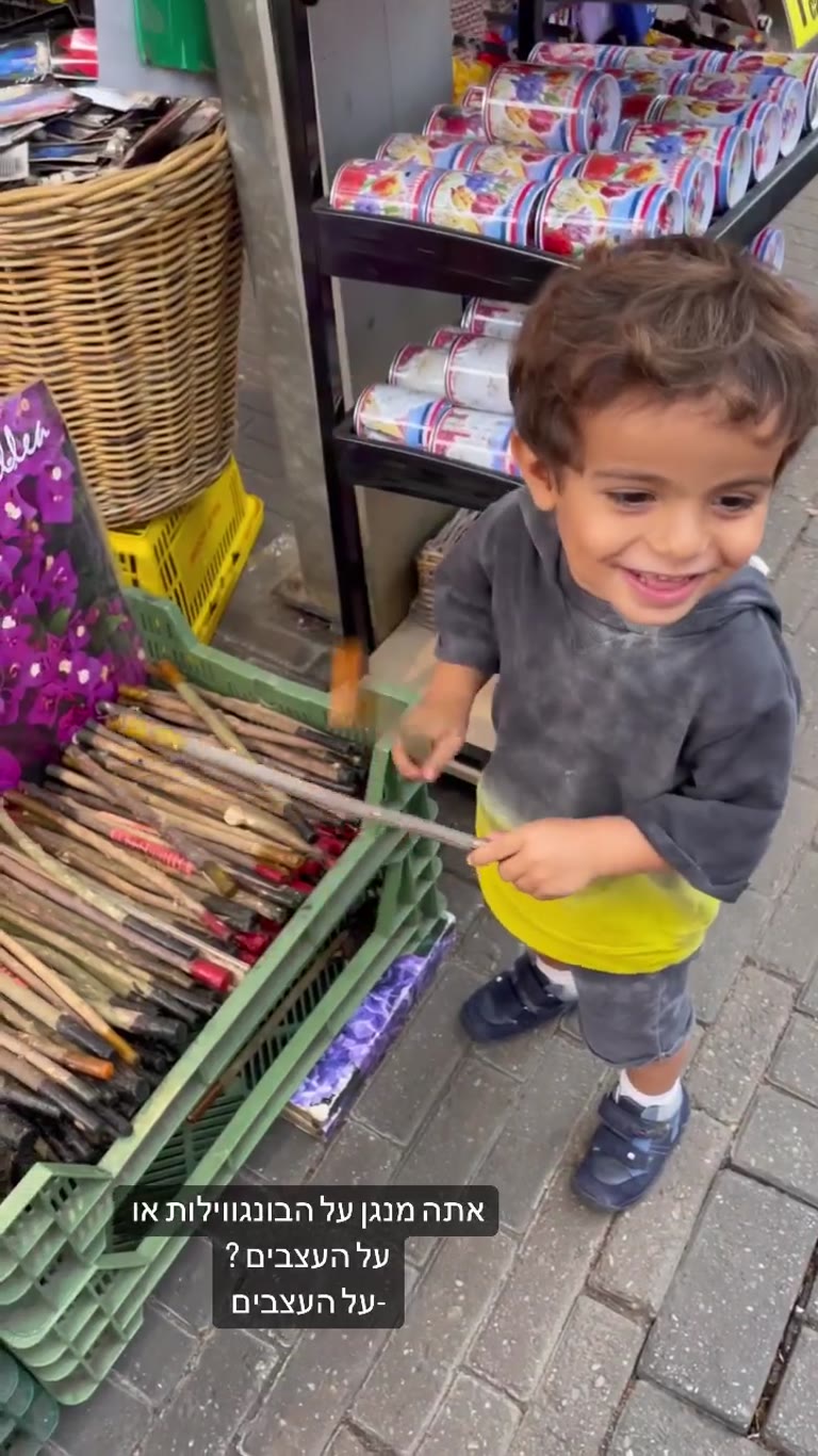 תינוק מנגן על מקלות בחנות פרחים באמסטרדם