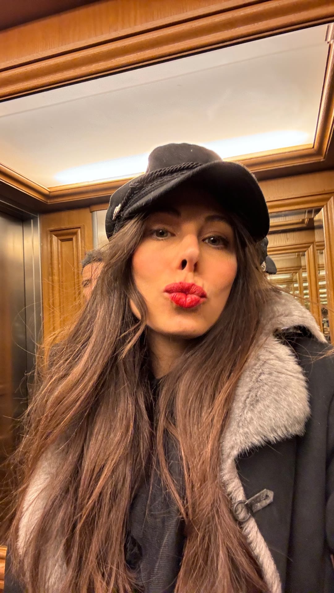 Winter selfie in a wood-paneled elevator, Paris
