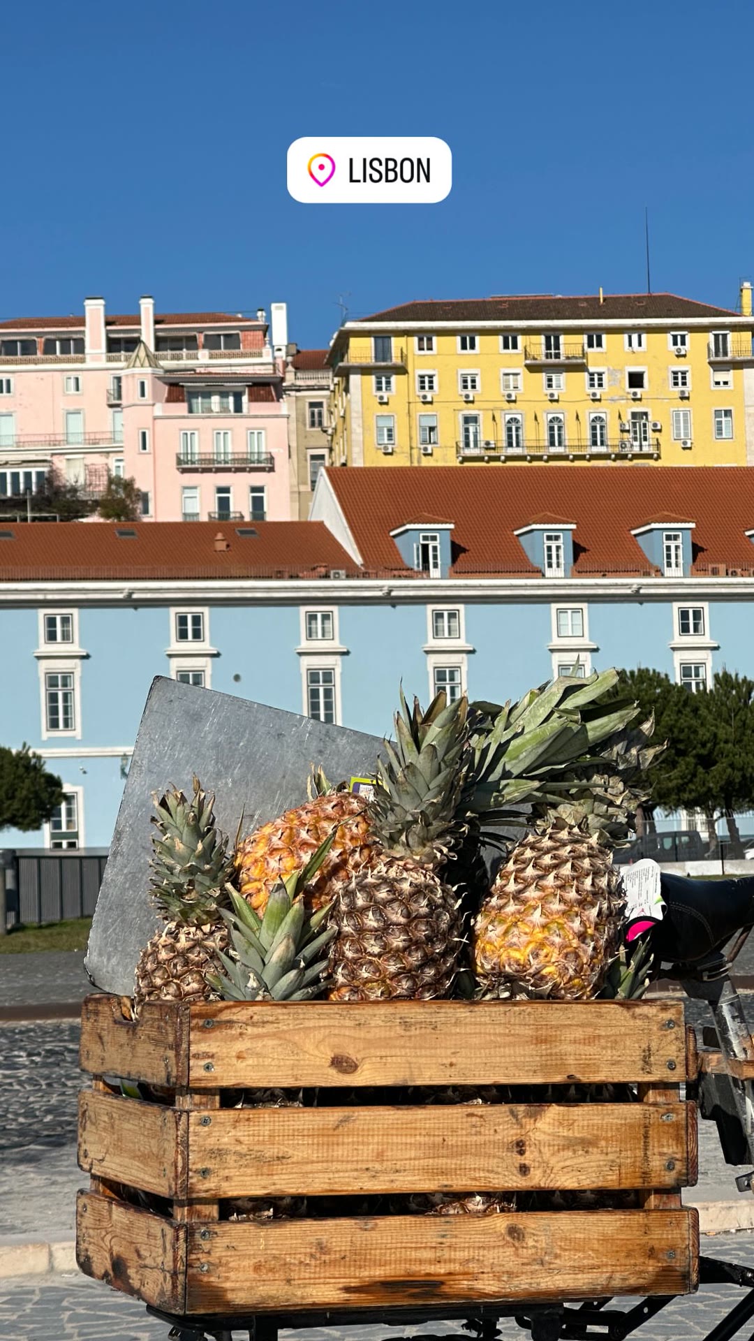 Lisbon street scene: pineapple cart by pastel façades