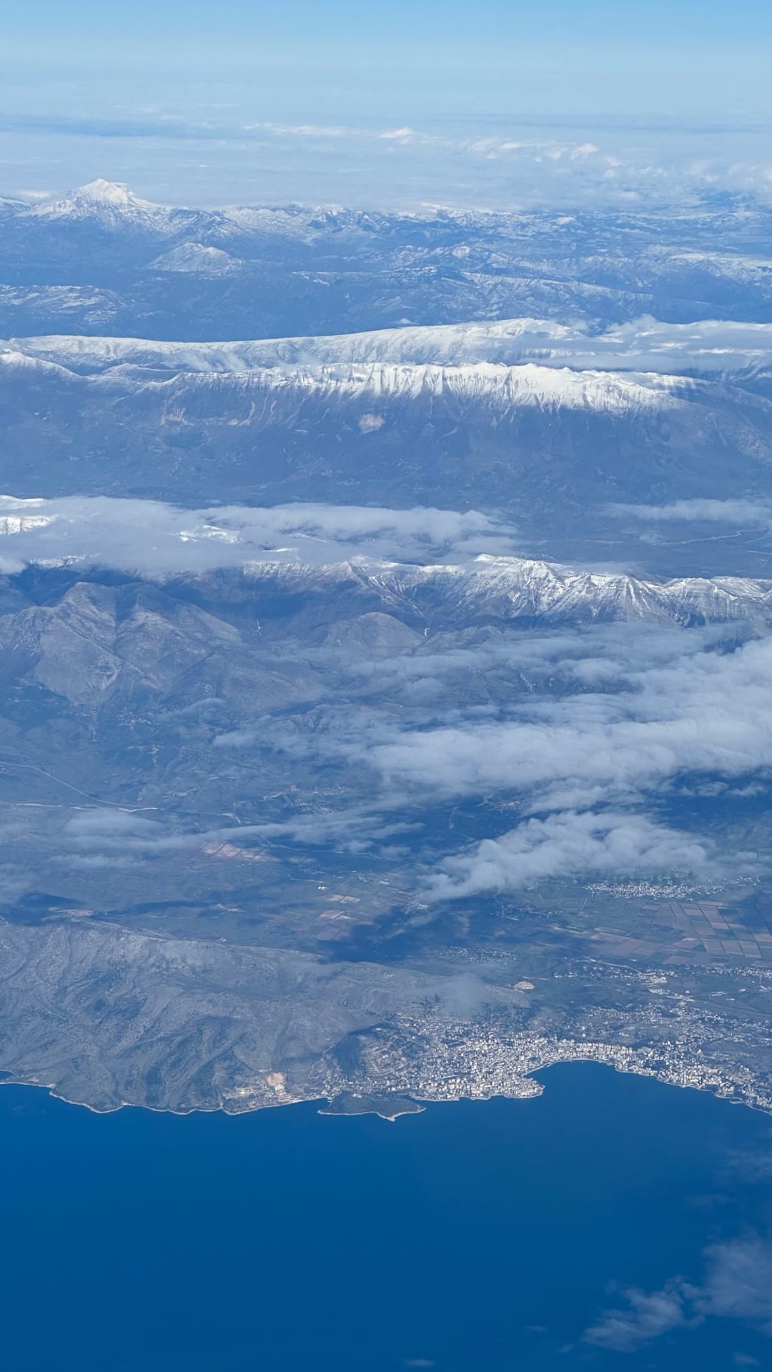 Snowy coastal mountains from the plane window