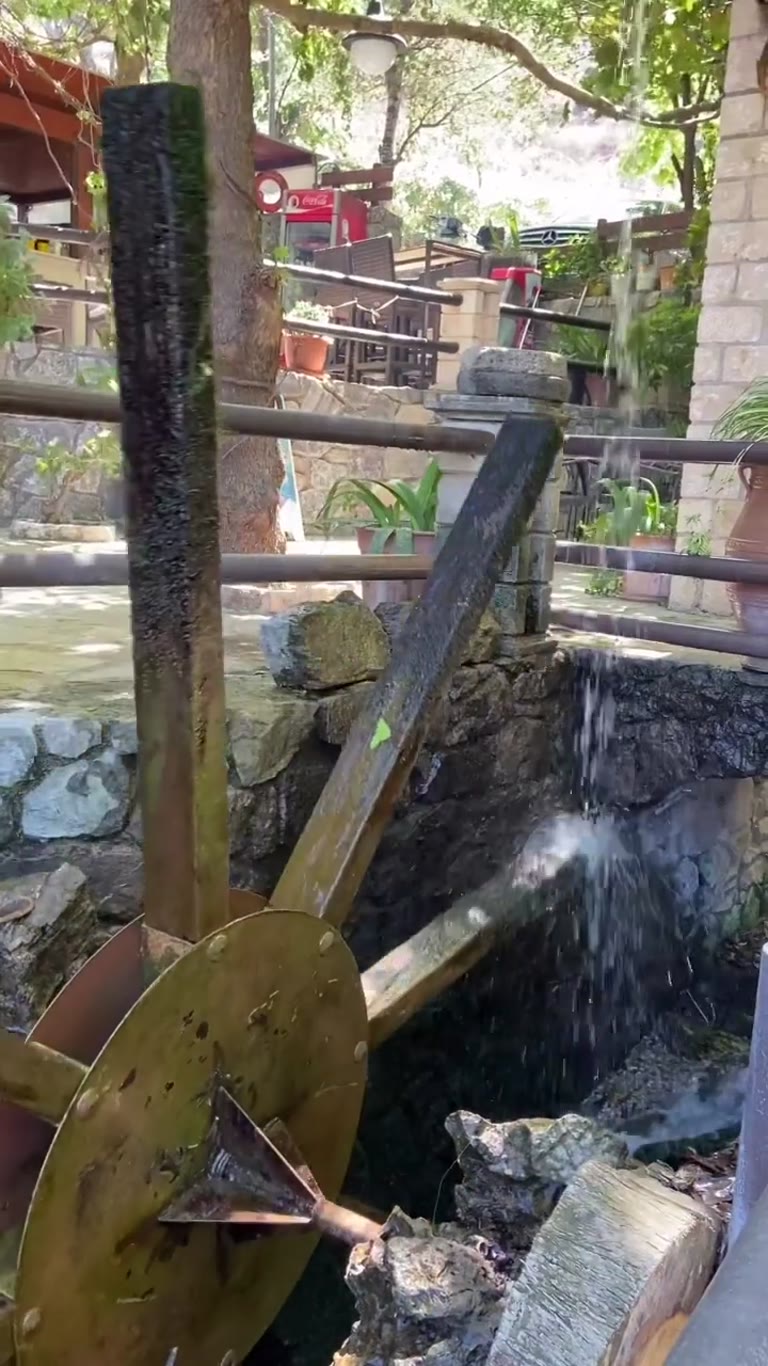 Shaded riverside taverna with watermill in Crete