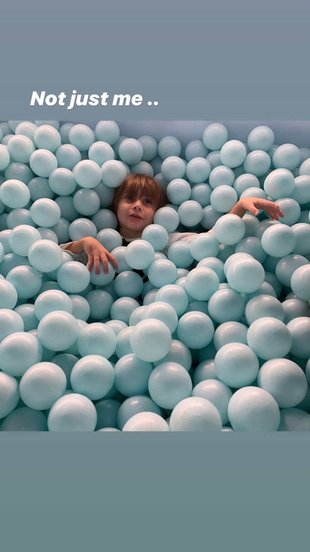 Kid buried in a pastel ball pit