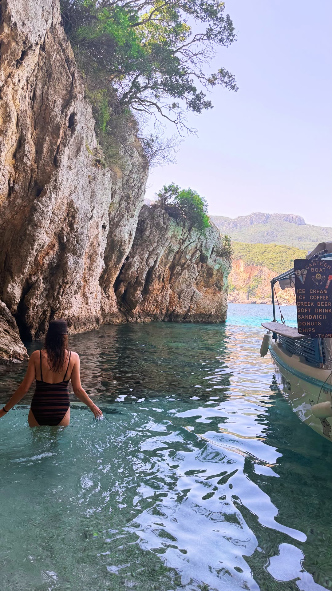 Swimming in a Corfu cove with a canteen boat