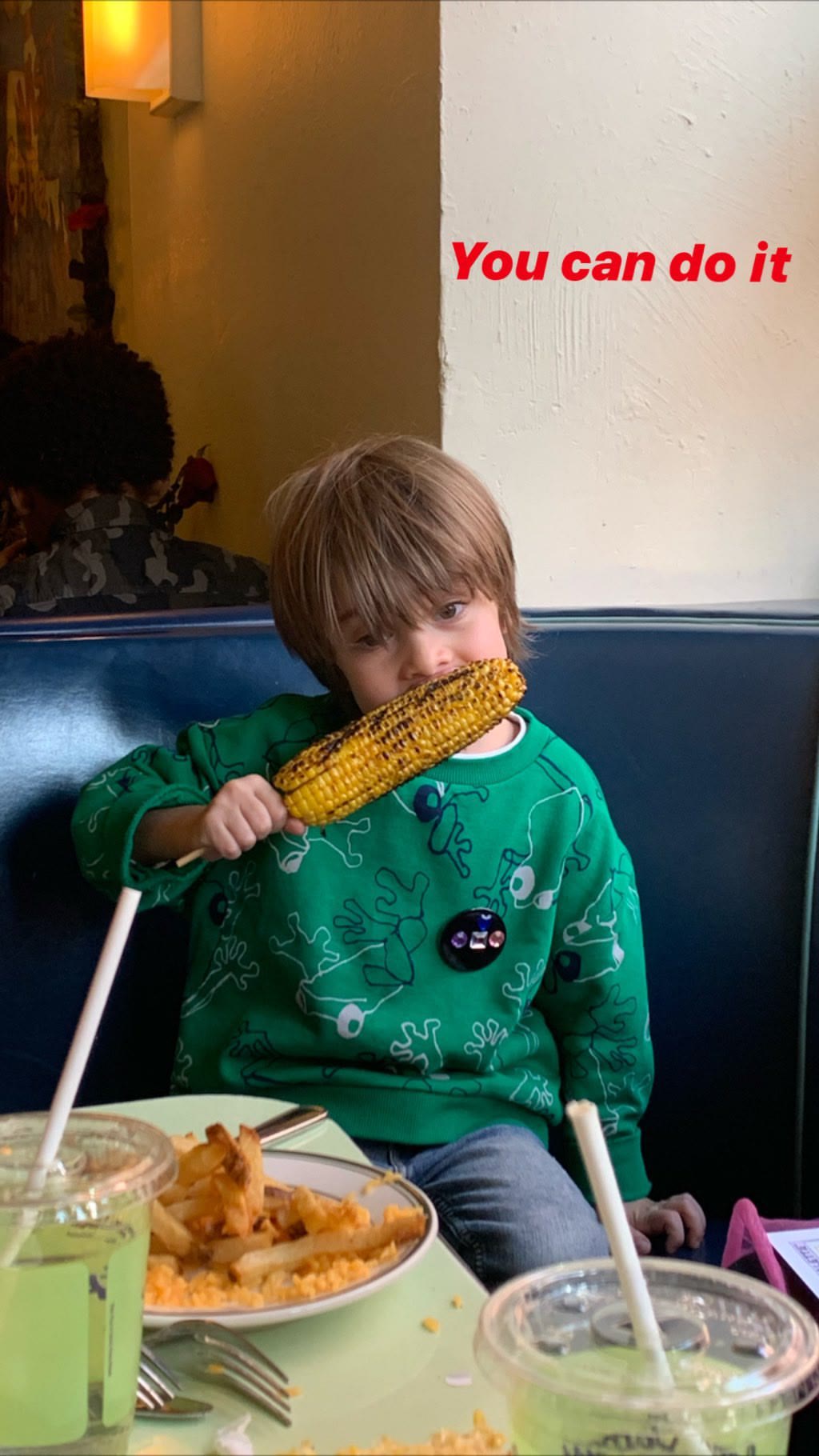 Kid tackling corn on the cob in NYC