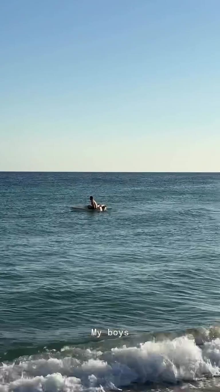 Kids on a paddleboard in the sea, Puglia