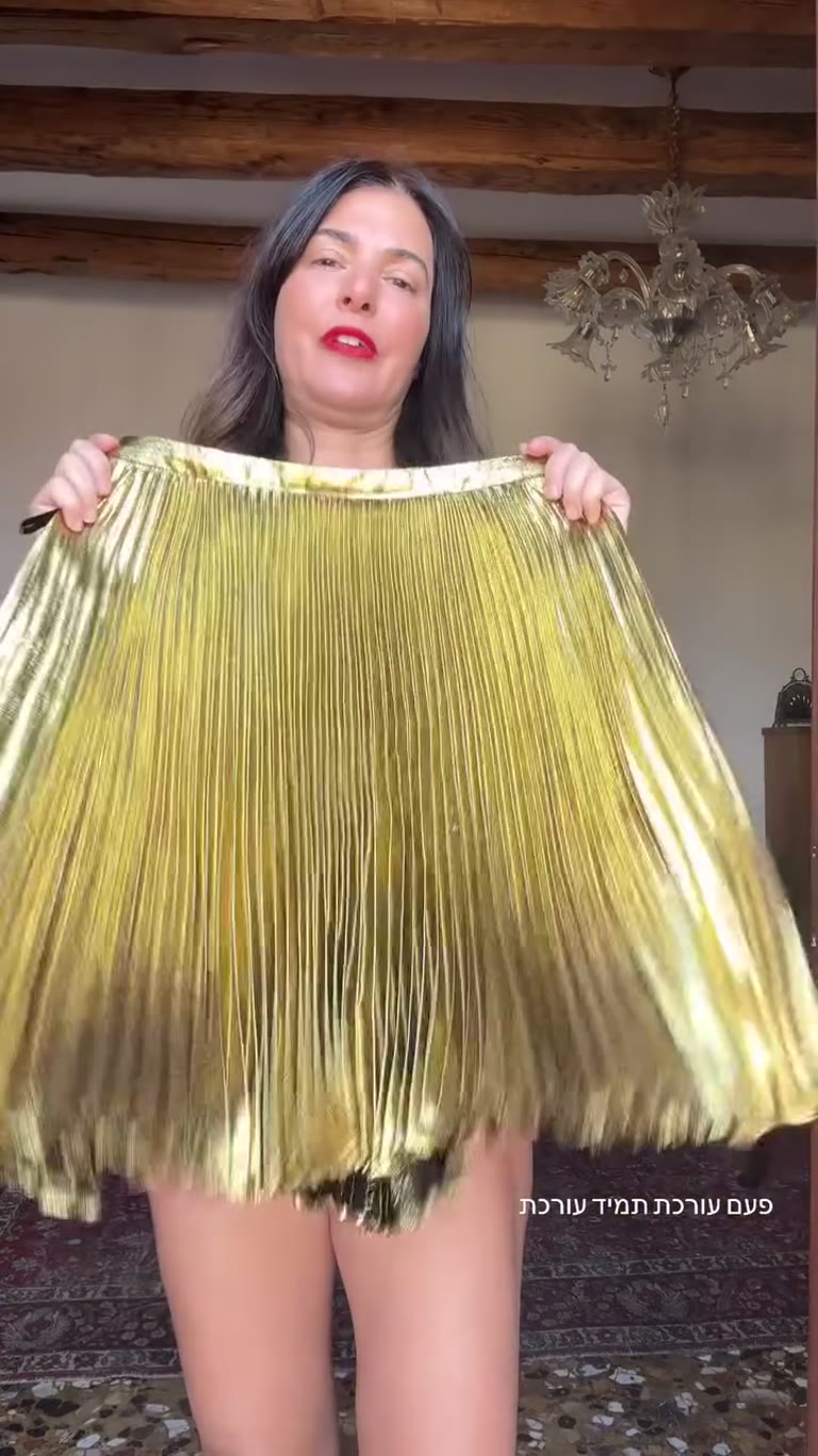 Getting dressed in a Venice apartment: gold pleated skirt