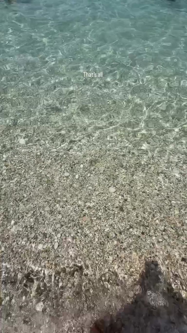 Crystal-clear water on a Corfu pebble beach