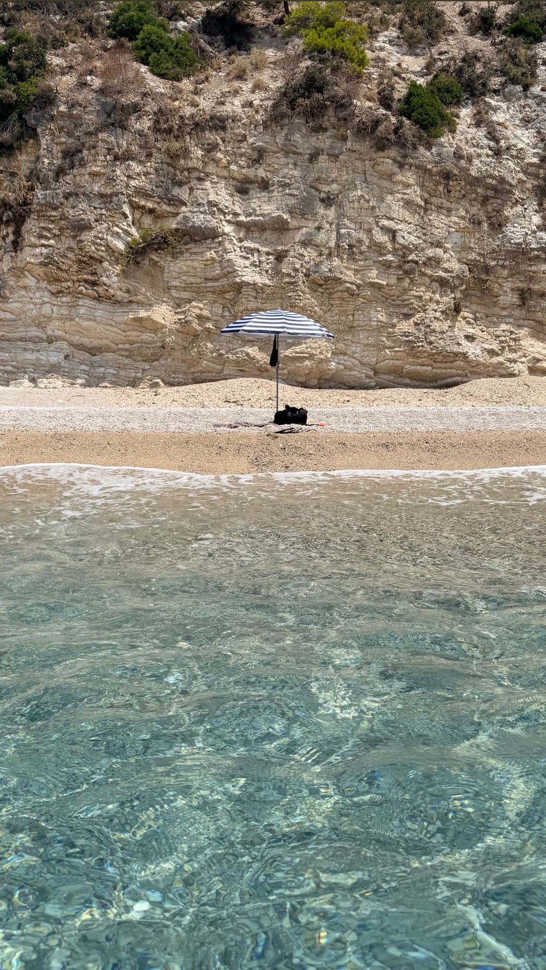 Empty cliff-backed beach in Corfu