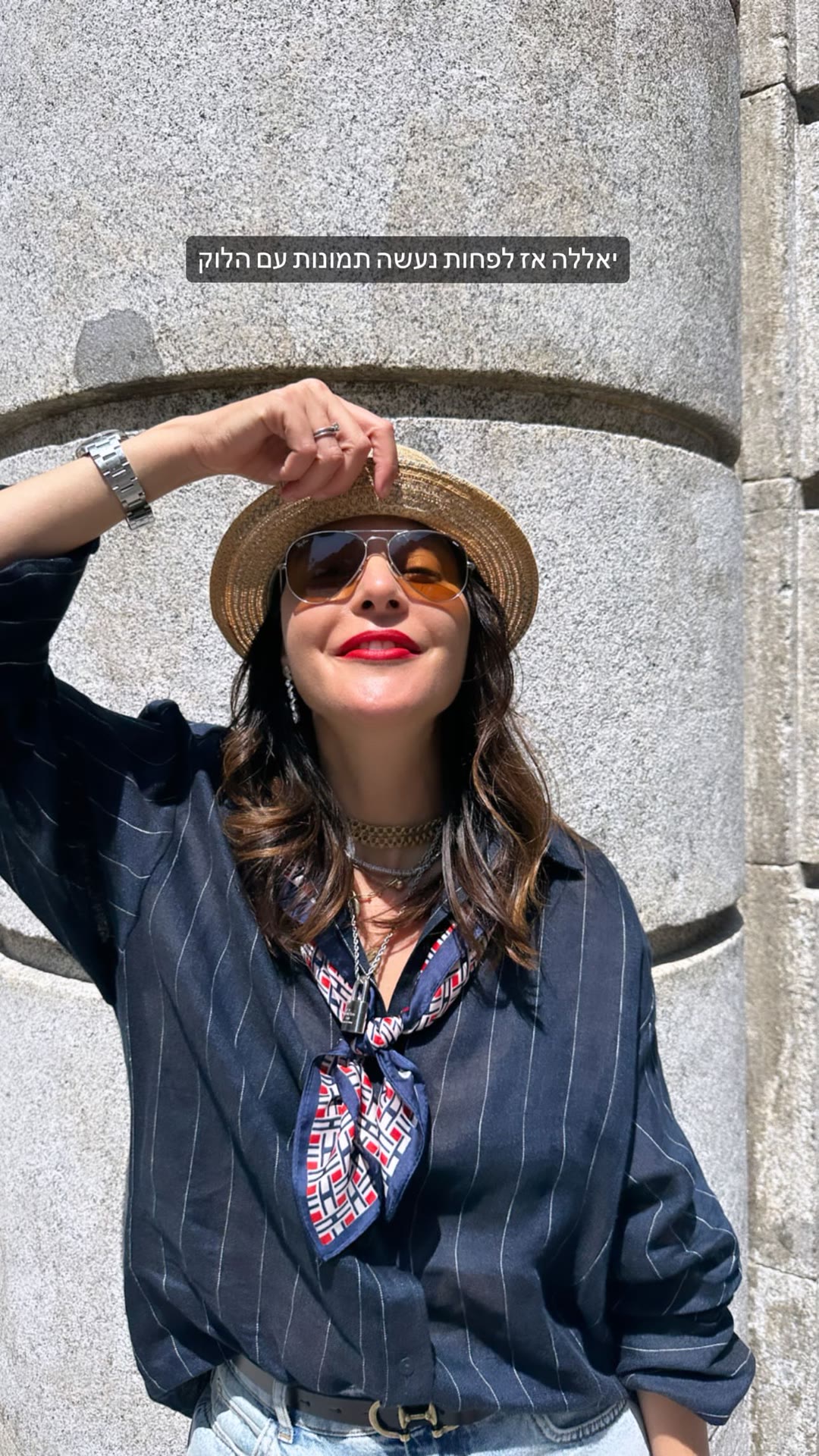 Outfit photos by a stone column in Madrid