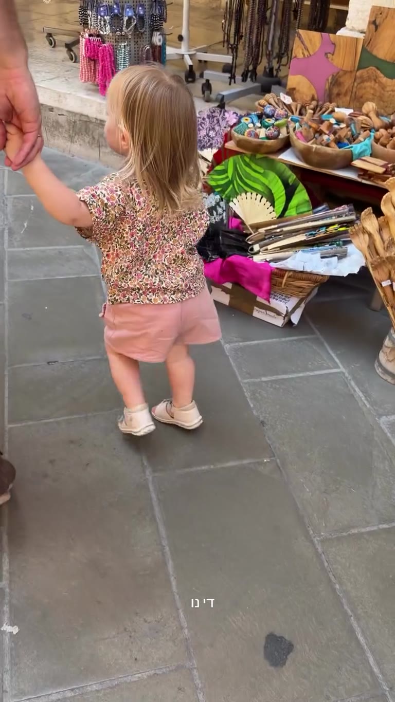 Toddler strolling Corfu's souvenir stalls