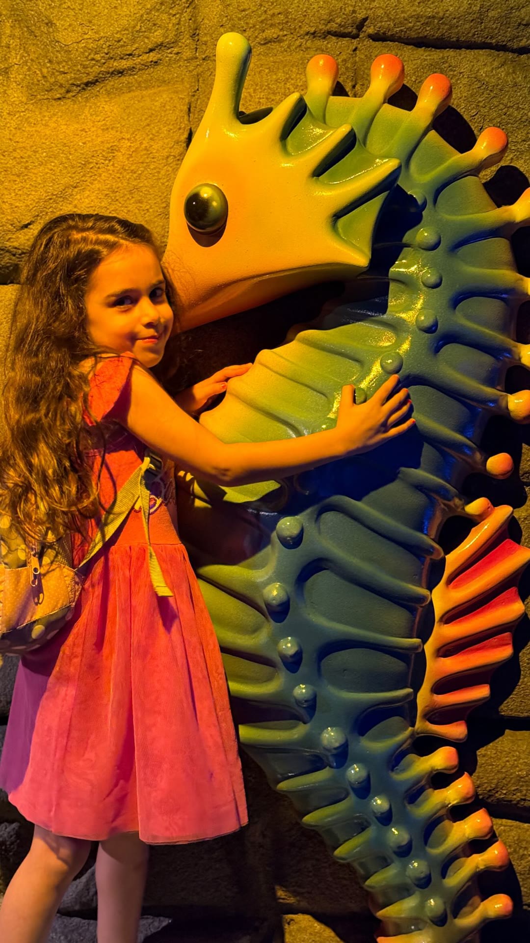 Kid hugging a giant seahorse at a Bangkok aquarium