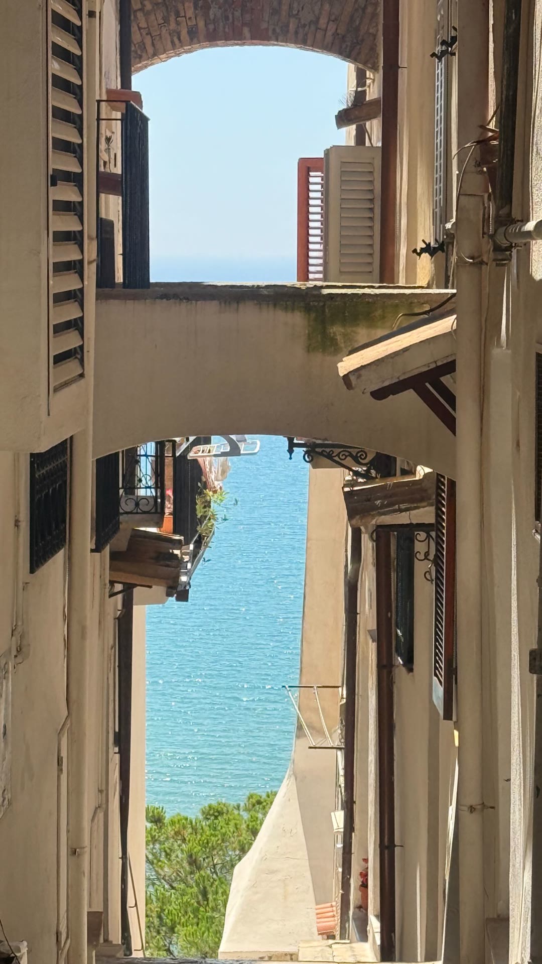 Sea view through a whitewashed alley near Rome