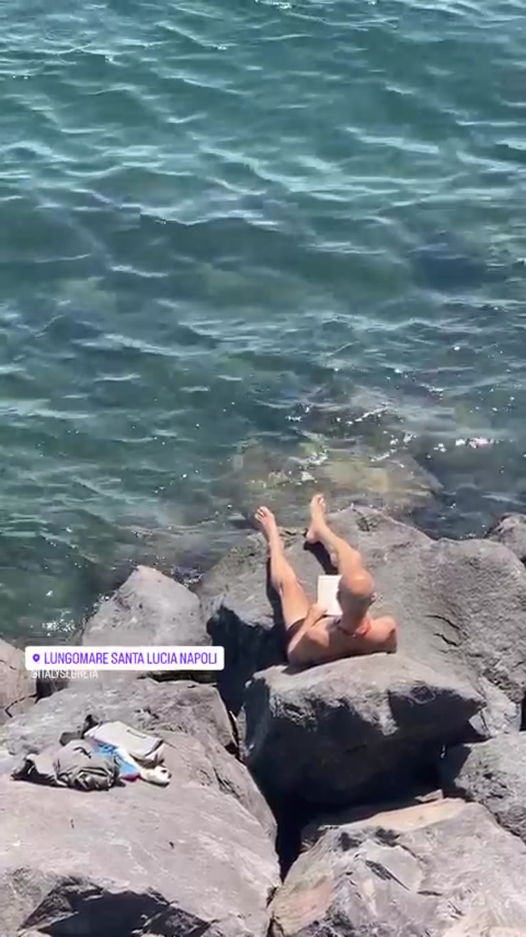 Reading on the rocks at Lungomare Santa Lucia, Naples