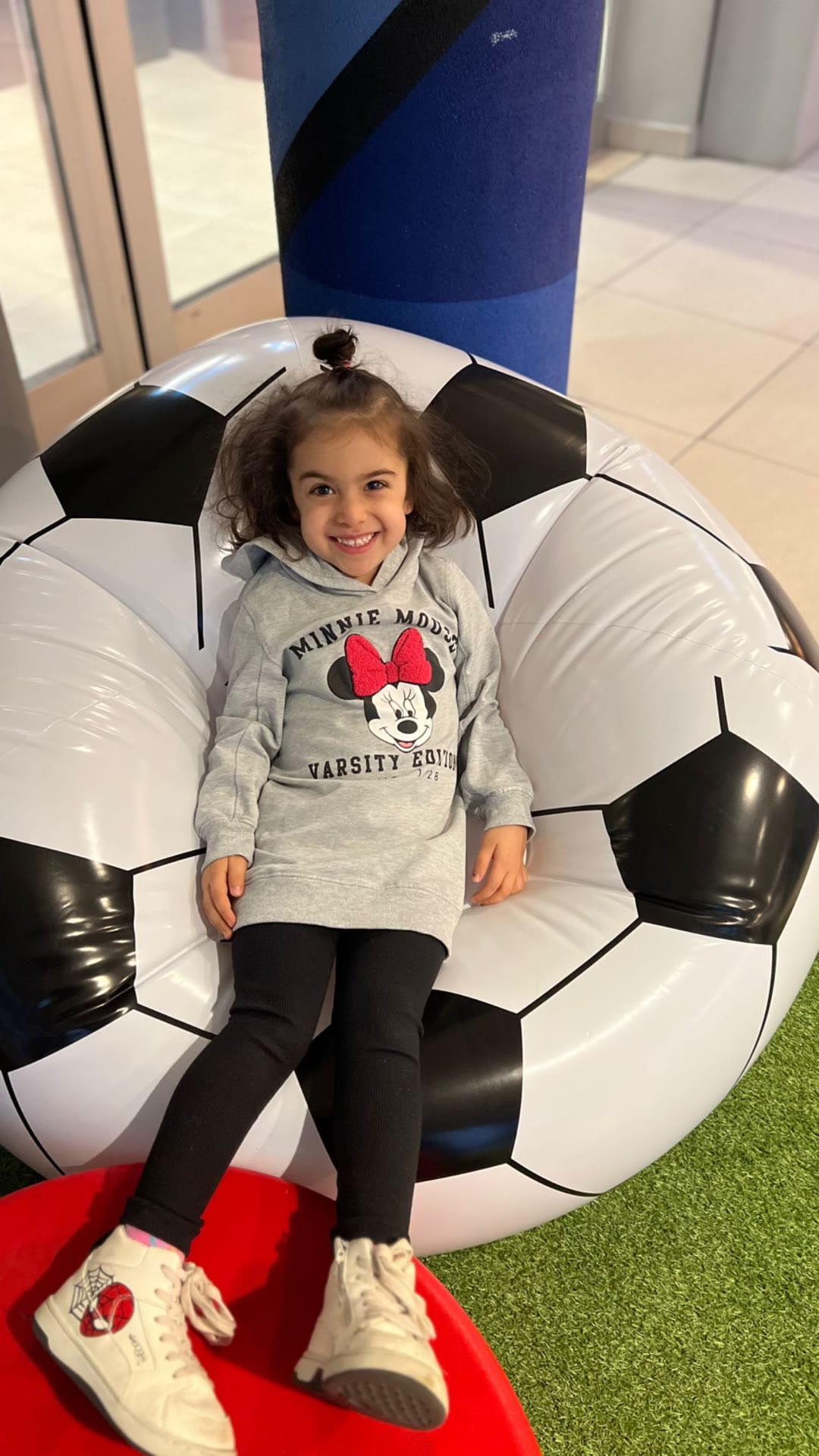 Kid on a giant soccer ball chair in Milan