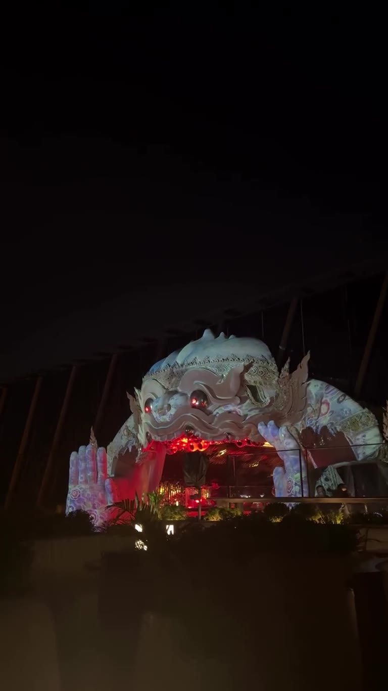 Giant yaksha bar lit up at night in Bangkok