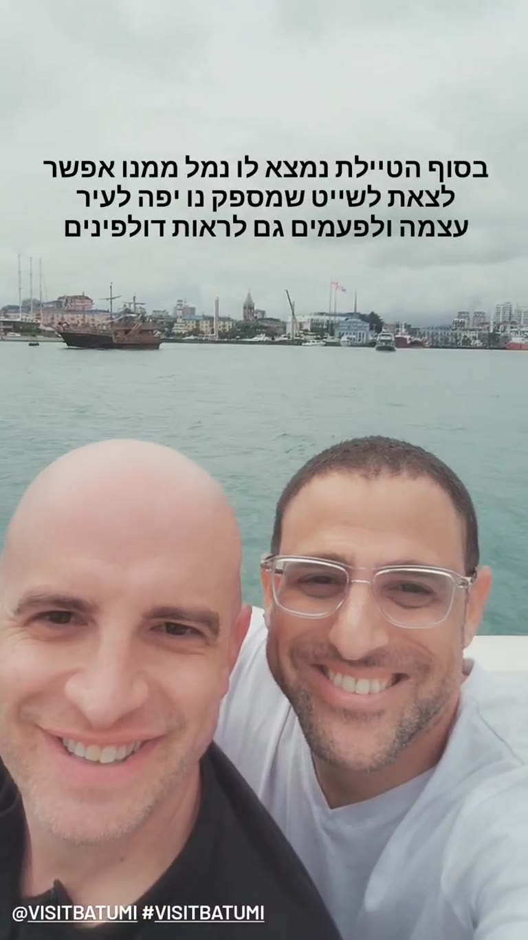 שייט מנמל באטומי עם נוף לעיר ודולפינים