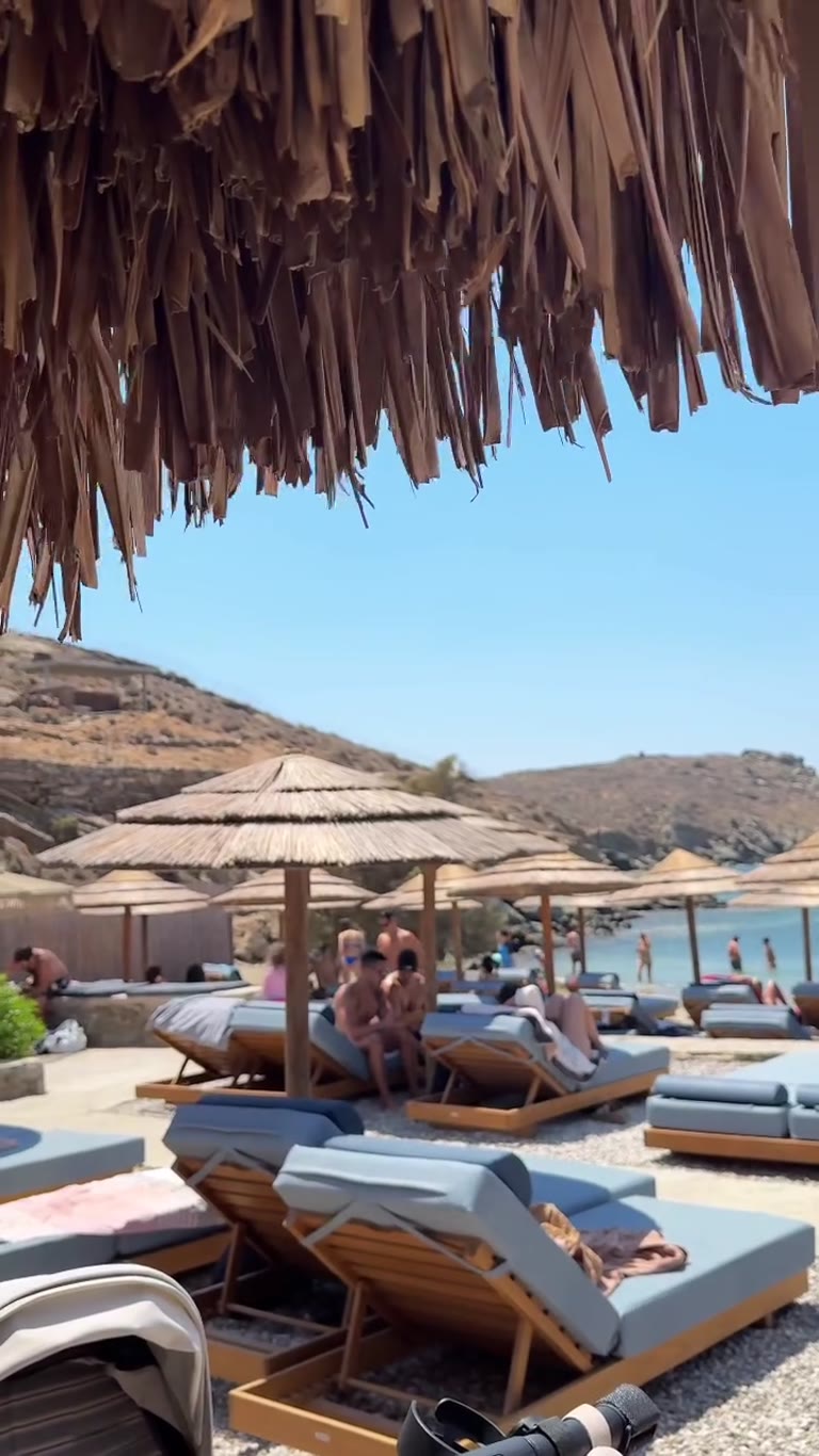 מועדון חוף עם שמשיות קש בטינוס