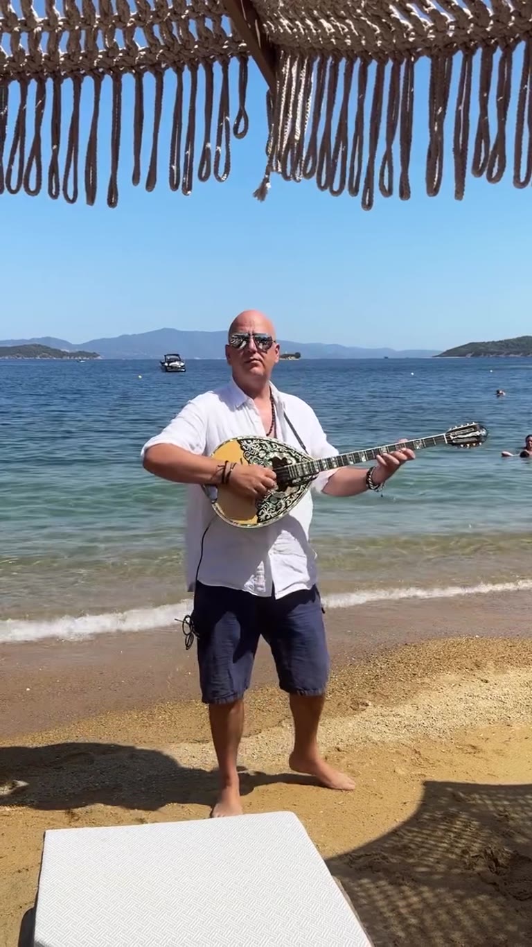 נגן בוזוקי על החוף ב-Baracoa Skiathos