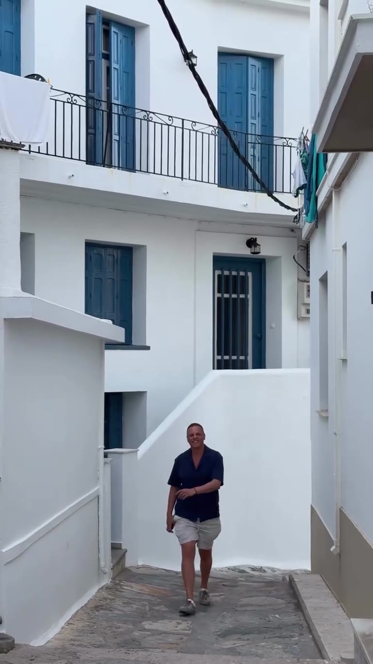 סמטה לבנה עם תריסים כחולים בסקופלוס