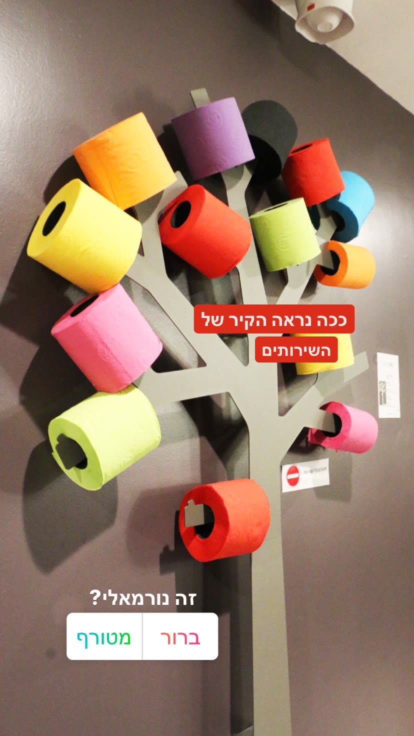 קיר עץ נייר טואלט צבעוני בשירותים בפריז