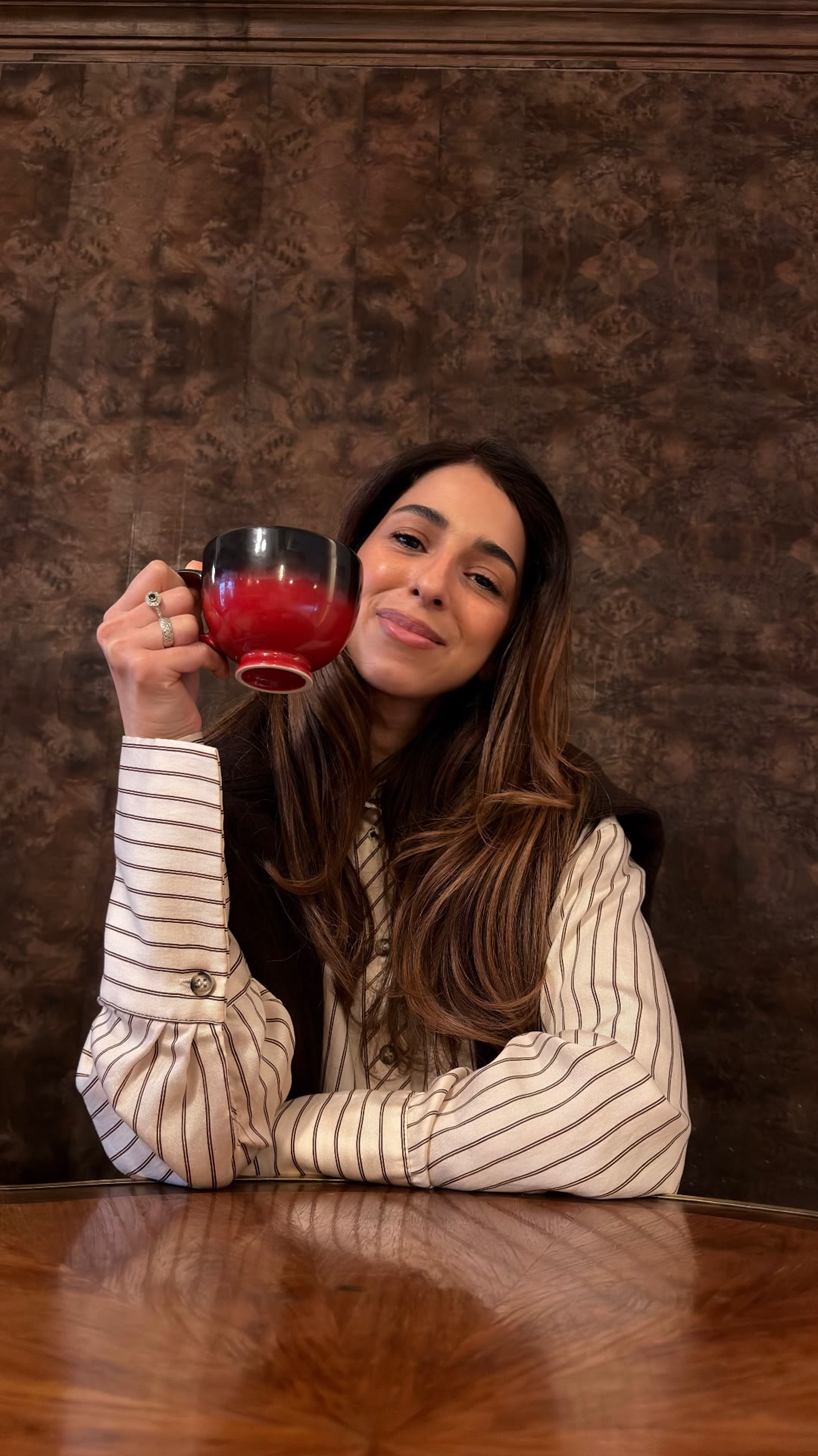 Coffee in a red cup at a wood-panelled café