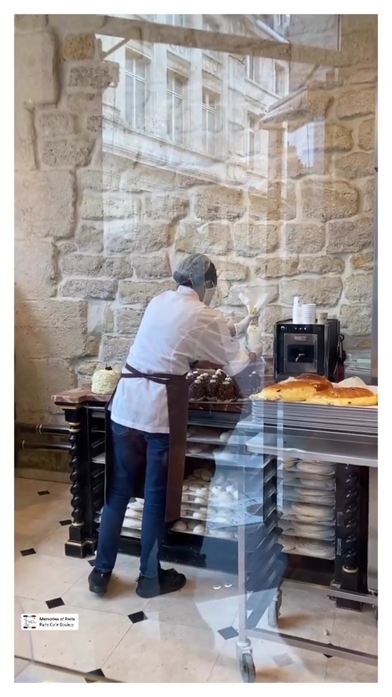 Pastry chef piping choux in a Paris bakery window