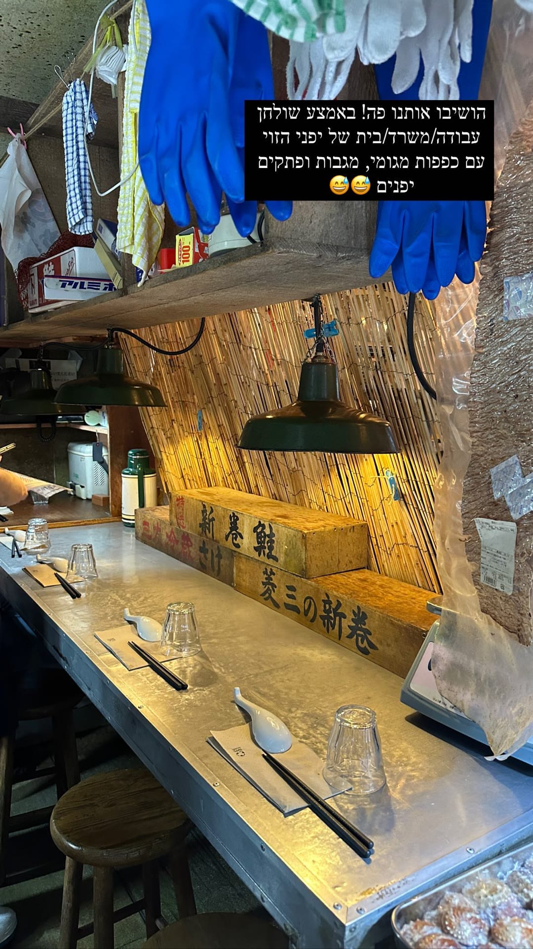 Seated at a work desk in a tiny Japanese eatery
