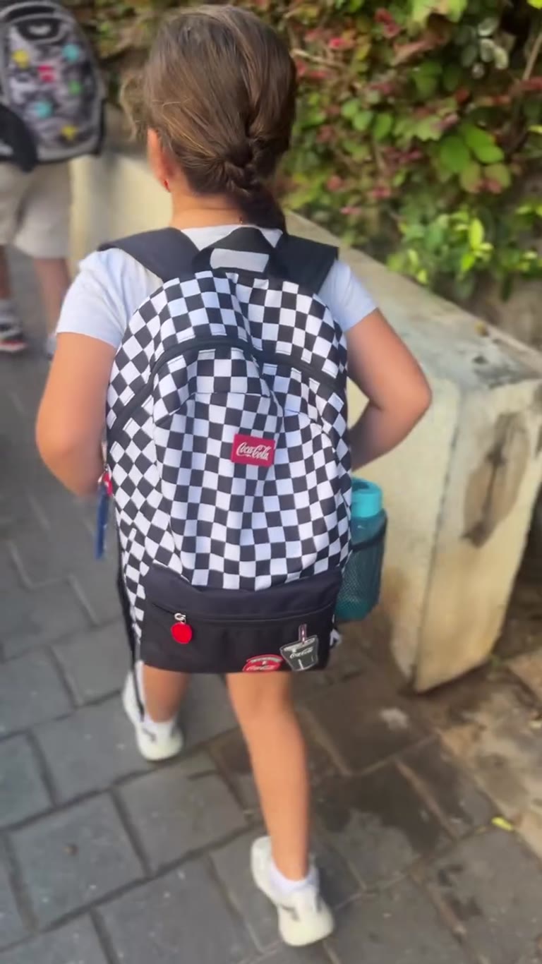 הבת של ליקוש בדרך לבית הספר עם תיק קוקה קולה